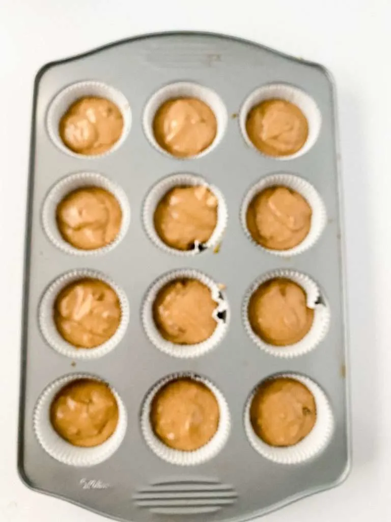 Cupcake pan filled with apple cider cupcakes batter.