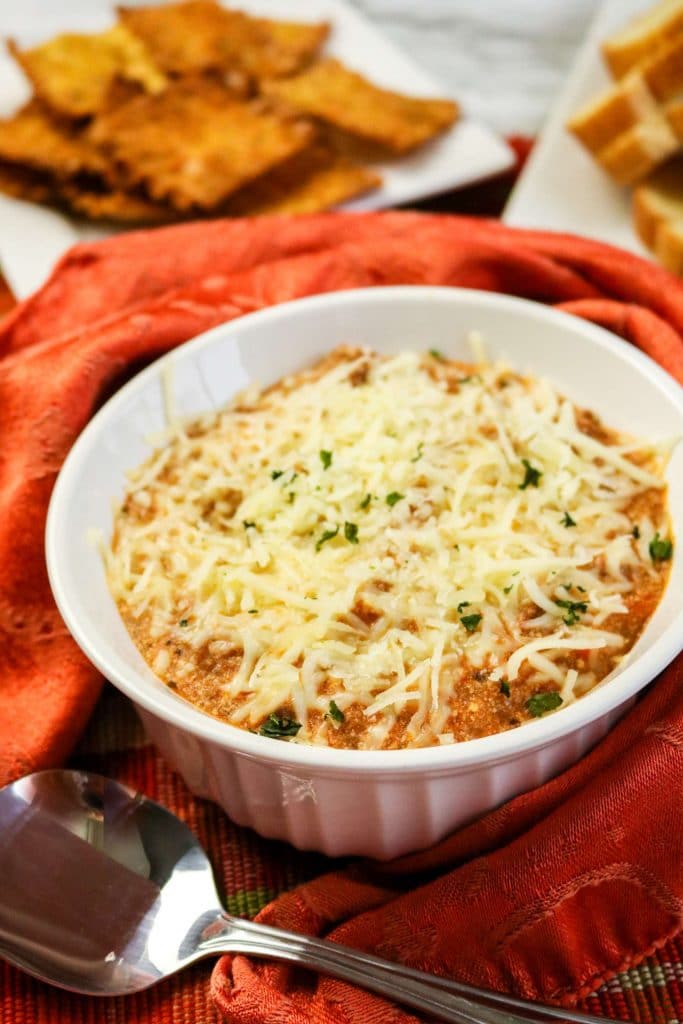 cheesy lasagna dip with ground beef with a bowl with spoon