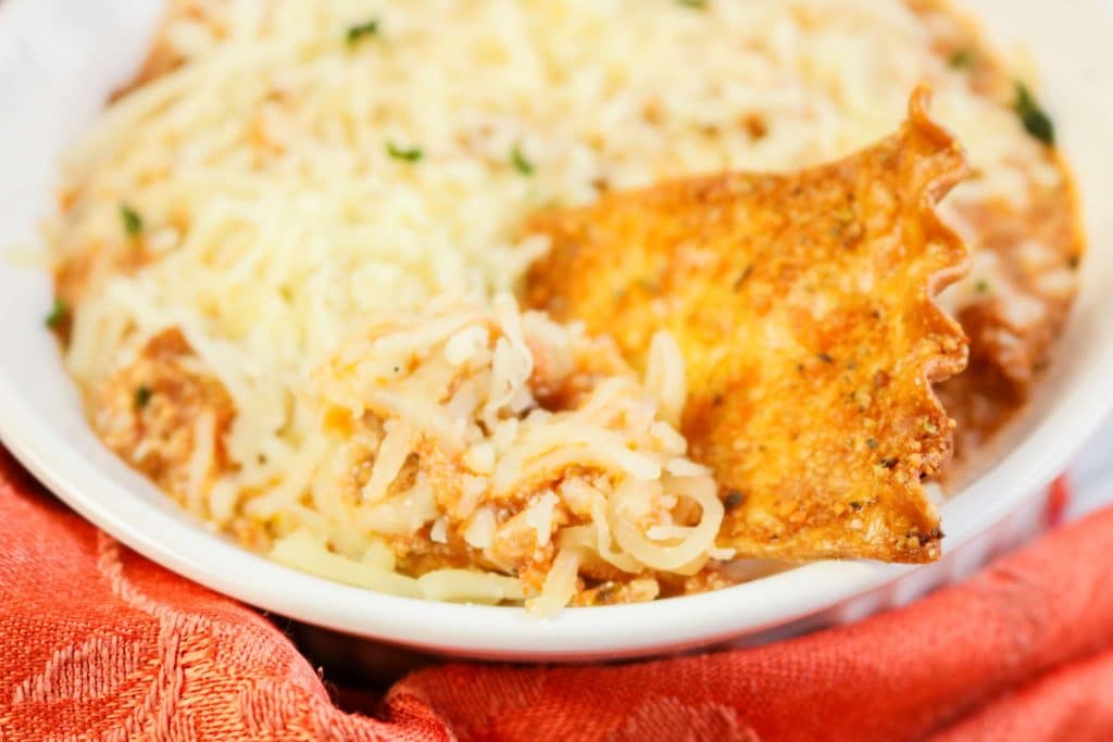 How To Make Cheesy Lasagna Dip With Ground Beef! (Party Recipe Dip!) 6 baked chip being dipped into a bowl od lasagna dip