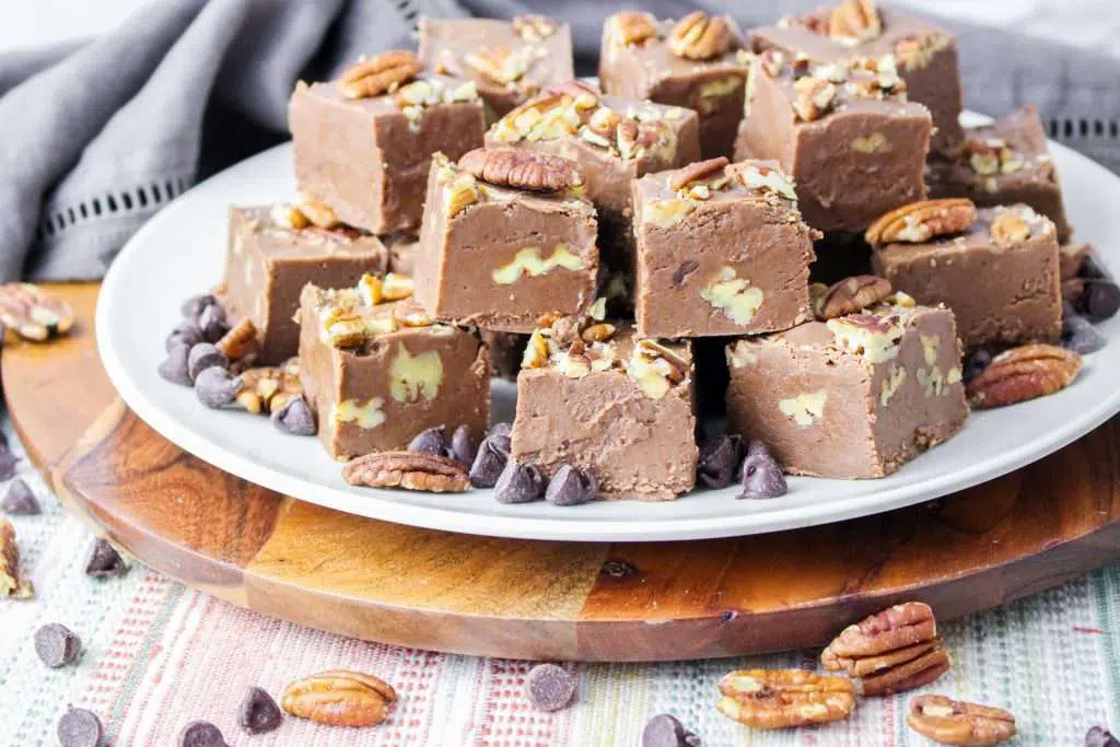 fudge topped with pecans and chocolate chips sitting on a plate