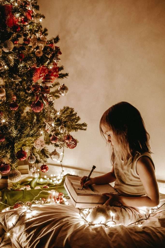 Christmas Gift Ideas for Toddler Girls 6 toddler girl playing with a toy underneath the christmas tree