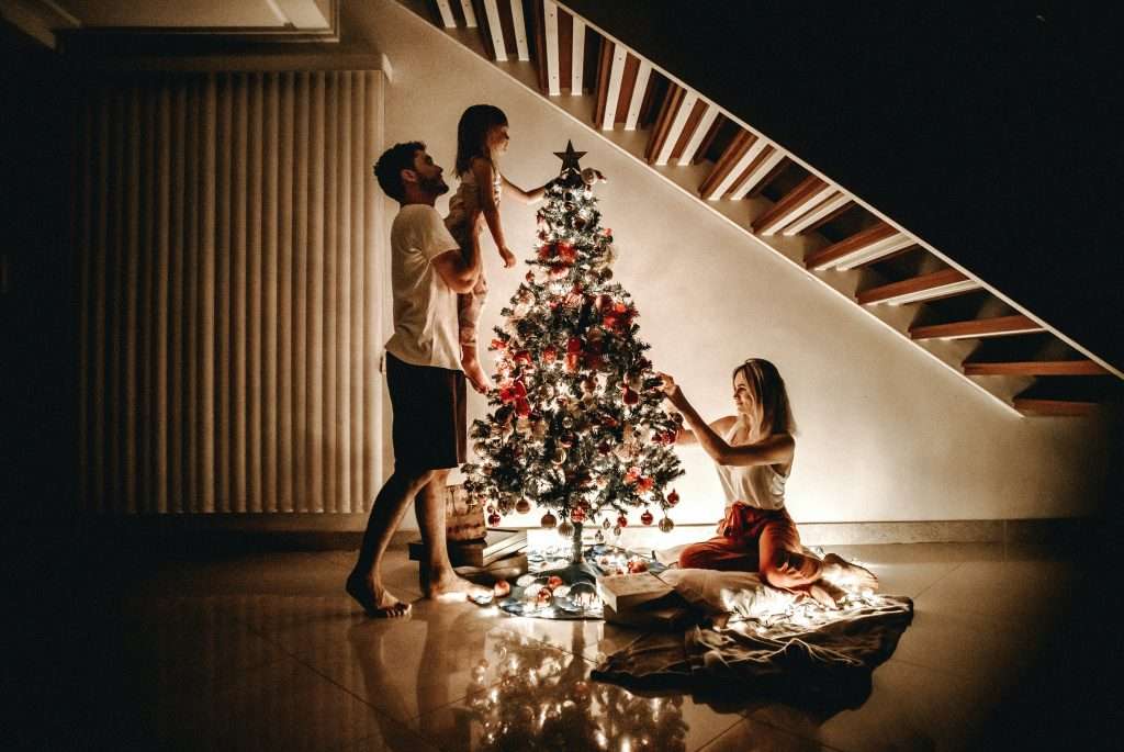 family decorating a christmas tree together