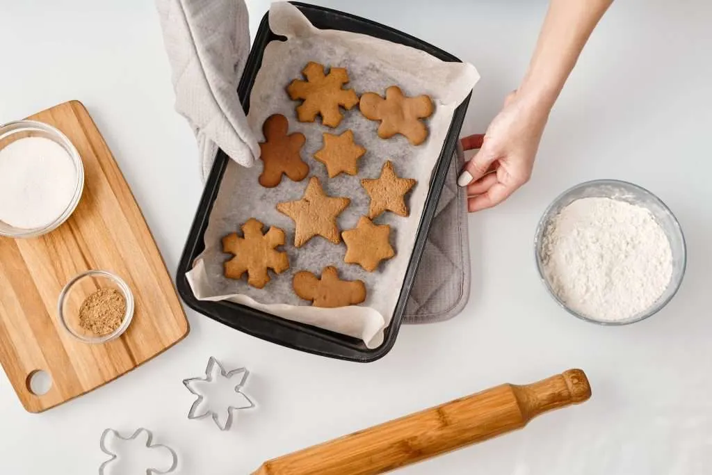 christmas cookies on a pan with cookie cutters and a rolling pin 