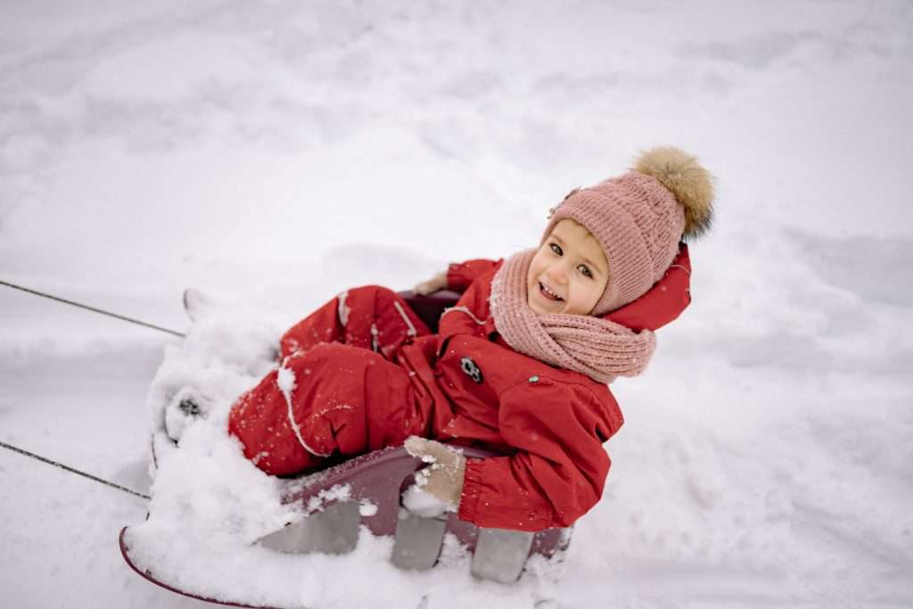 15 Winter Activities for Toddlers 5 toddler girl sledding in the snow