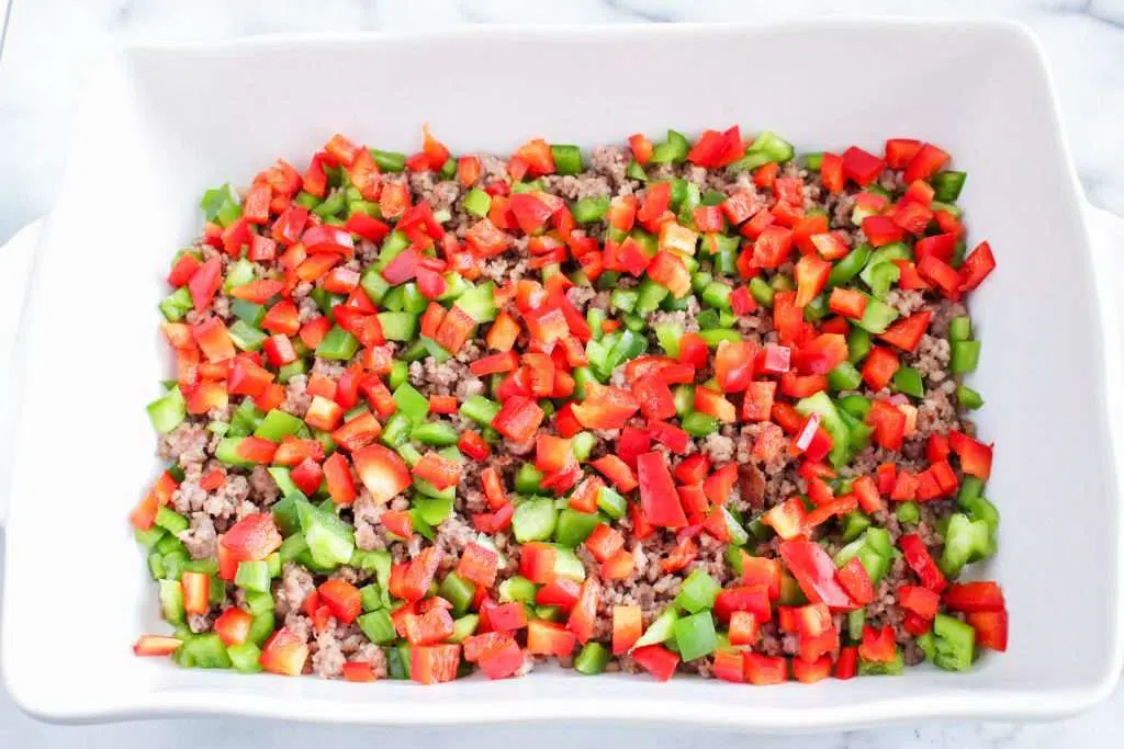 diced peppers and sausage in baking dish 