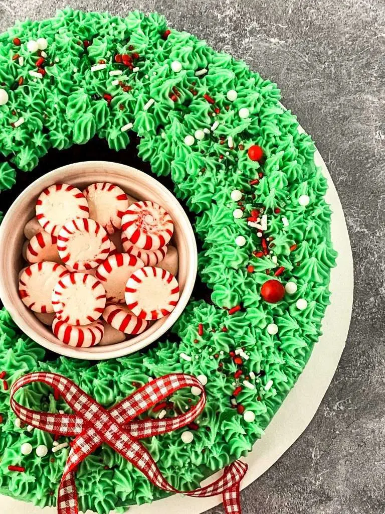 wreath christmas cake made out of red velvet cake mix, green icing, and sprinkles