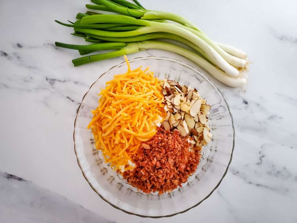 Neiman Marcus Dip 7 neiman marcus ingredients in glass bowl with green onion bundle behind it
