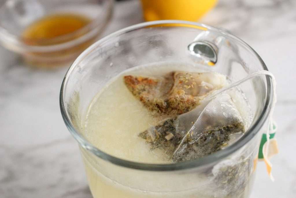 Starbucks Medicine Ball Tea Recipe (Copycat Recipe) 28 Close up of glass with hot water, lemonade, and tea bags.