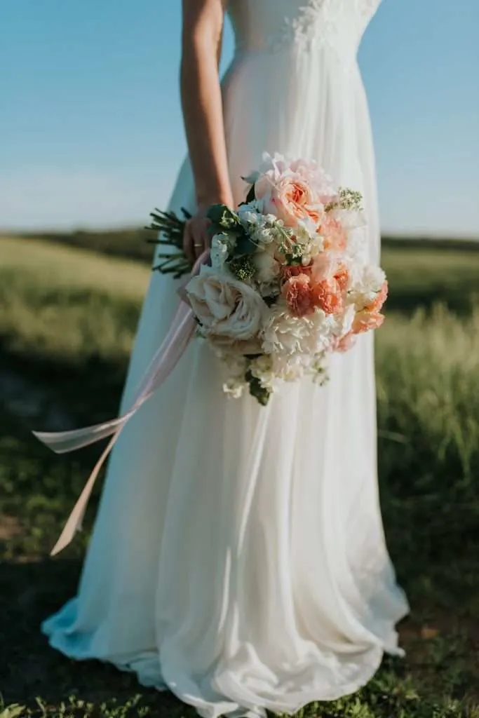 woman in a wedding dress holding a bouquet of flowers