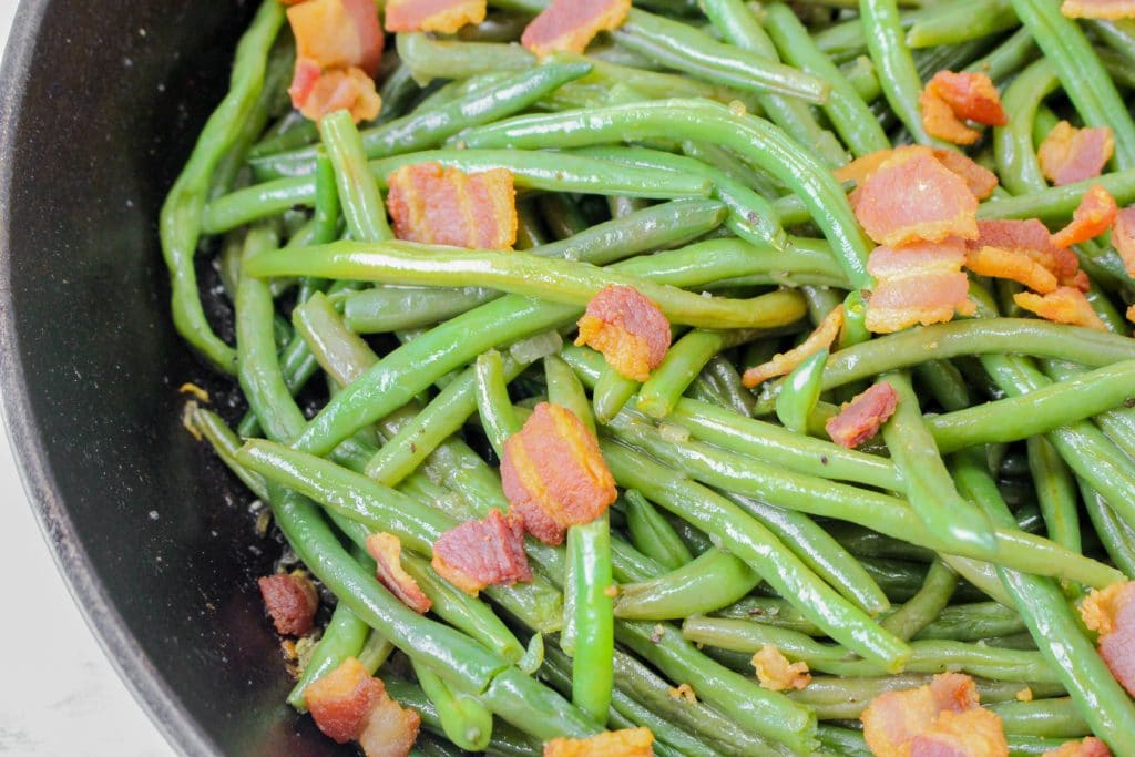 fresh green beans with bacon in a pan