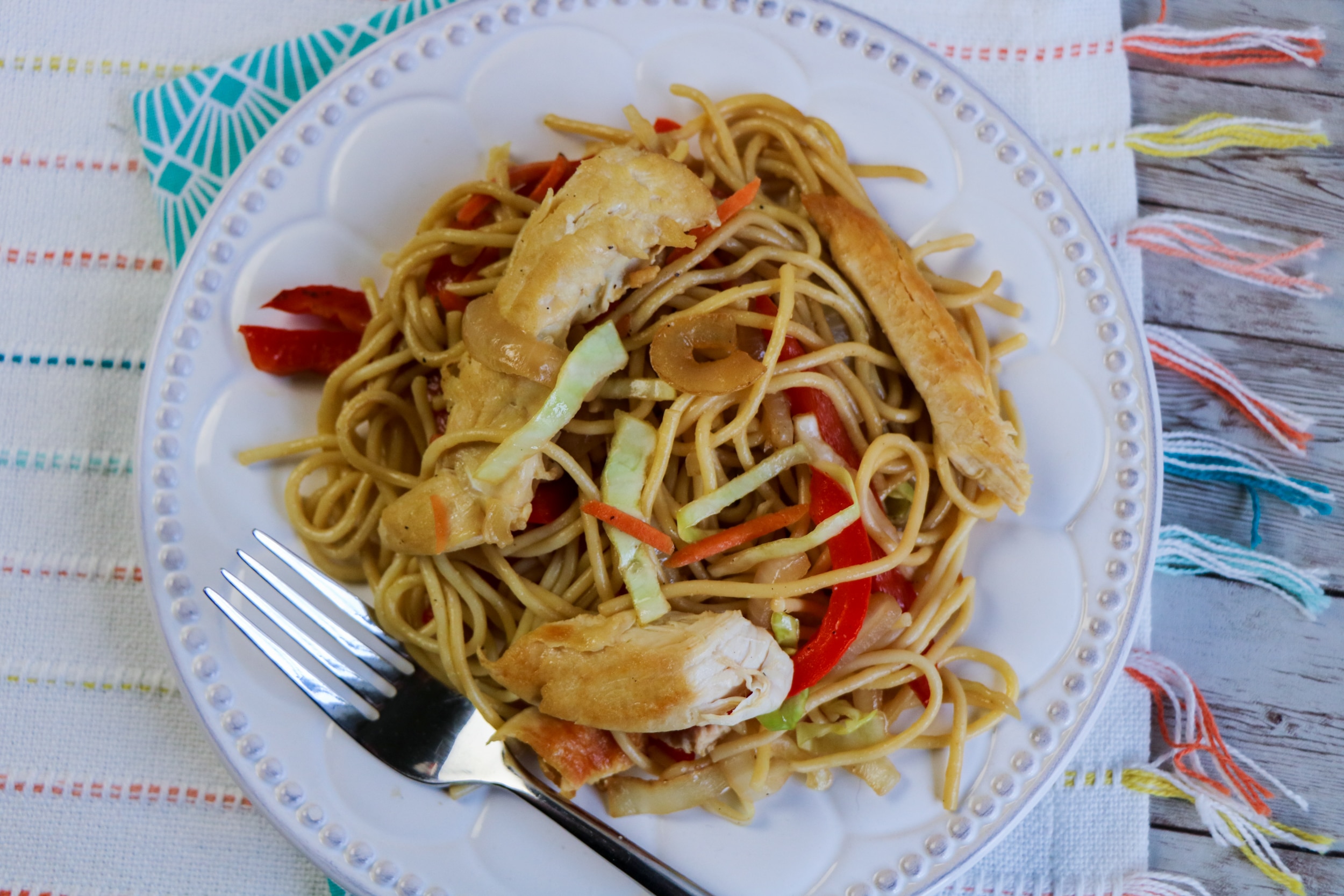 overlook of chicken lo mein on a white plate