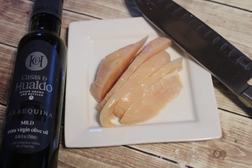 Savory Chicken Turnovers Recipe 6 sliced chicken on white plate with knife and olive oil