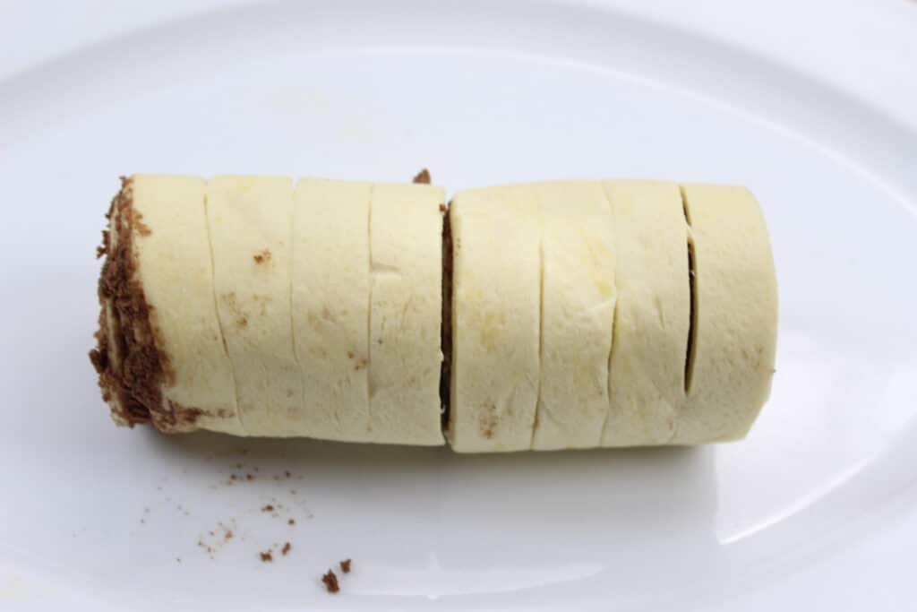 Pumpkin Cinnamon Rolls (3 Ingredients) 10 Roll of refrigerated cinnamon rolls rolled up on white plate.