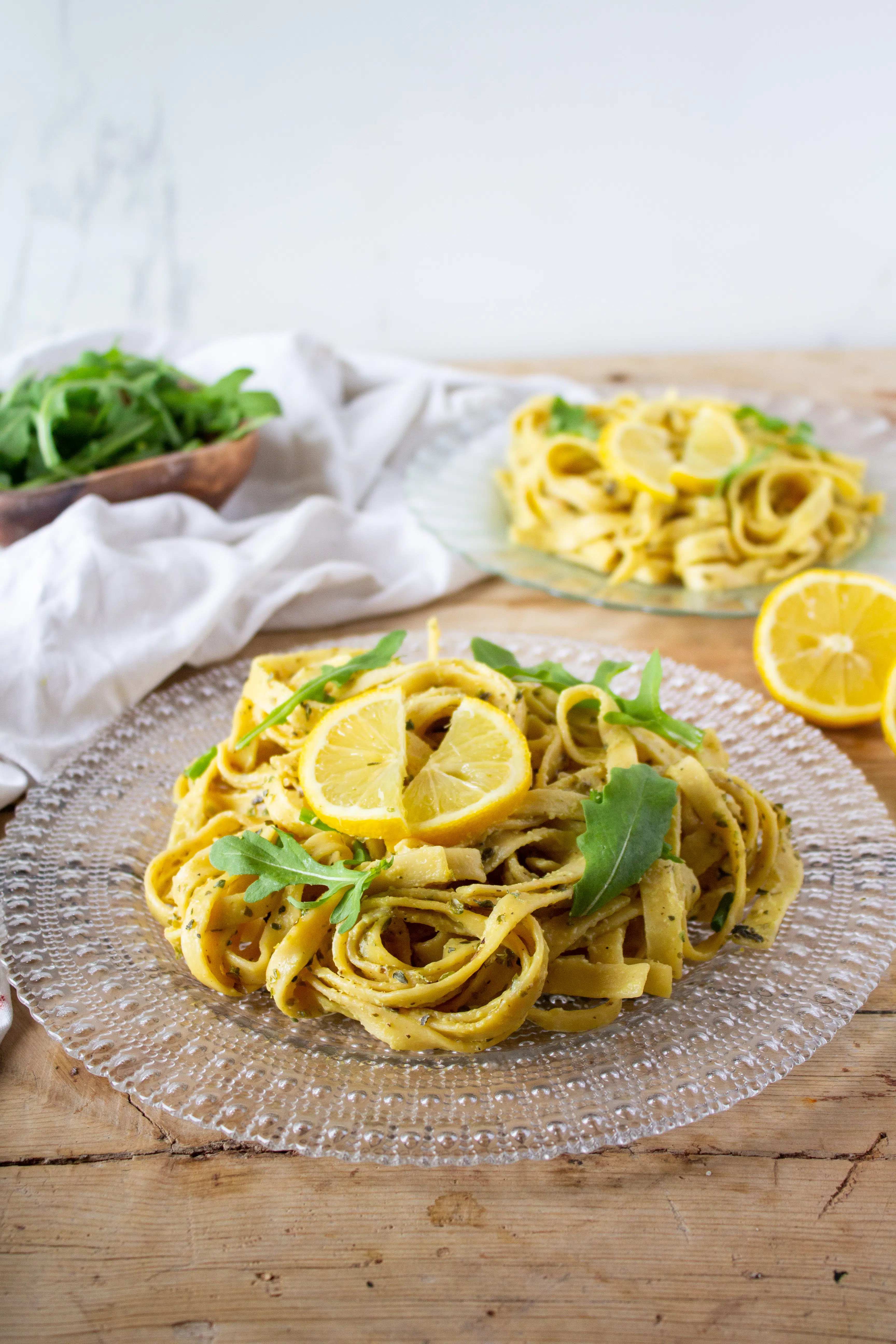 one pot lemon pasta on a clear plate with lemon on top