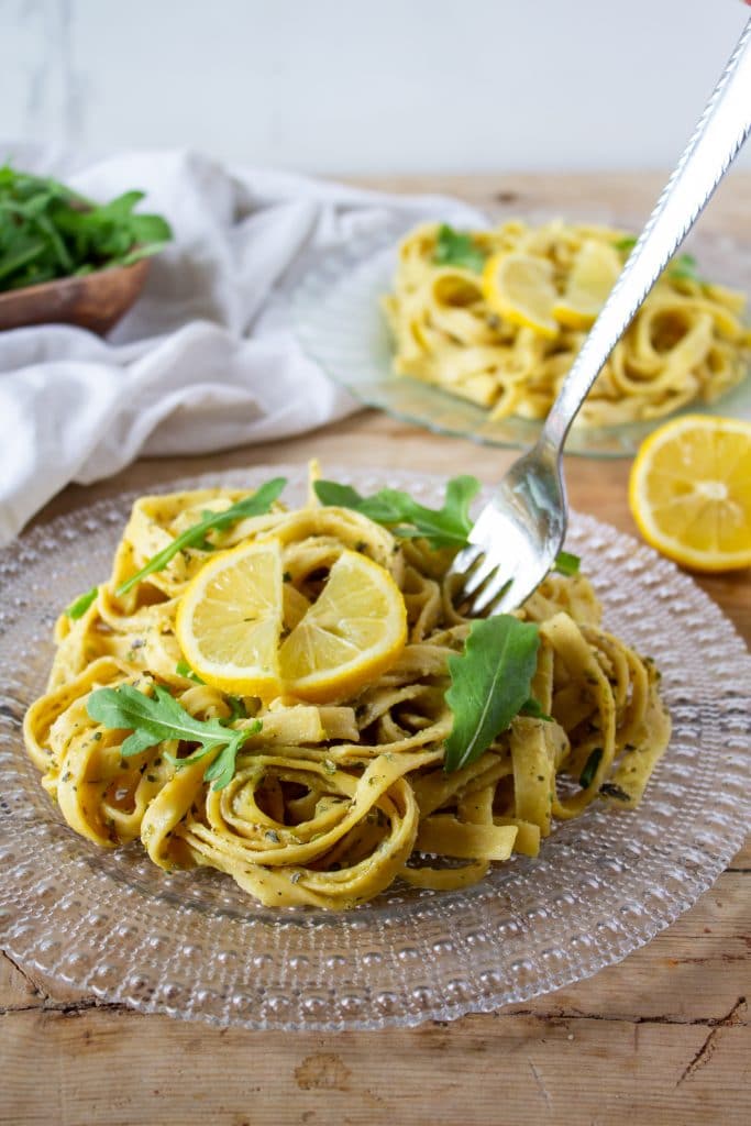 Quick One-Pot Lemon Pasta Recipe 2 lemon pasta on clear plate with lemon slice on top