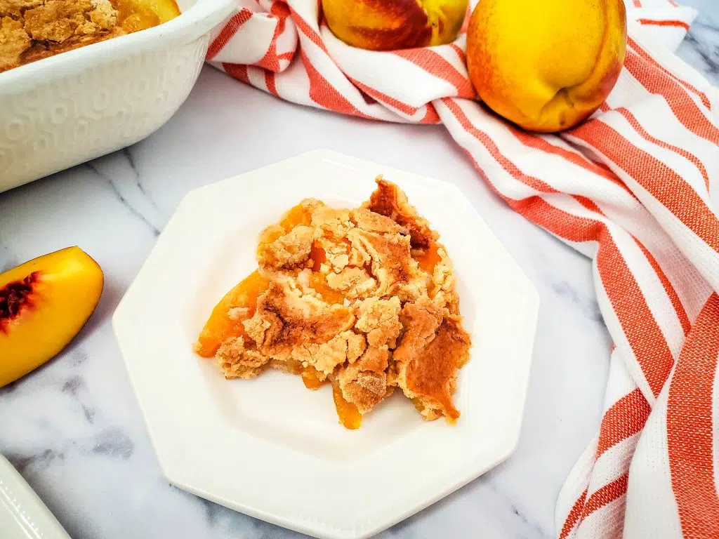dump cake with peaches on a plate 