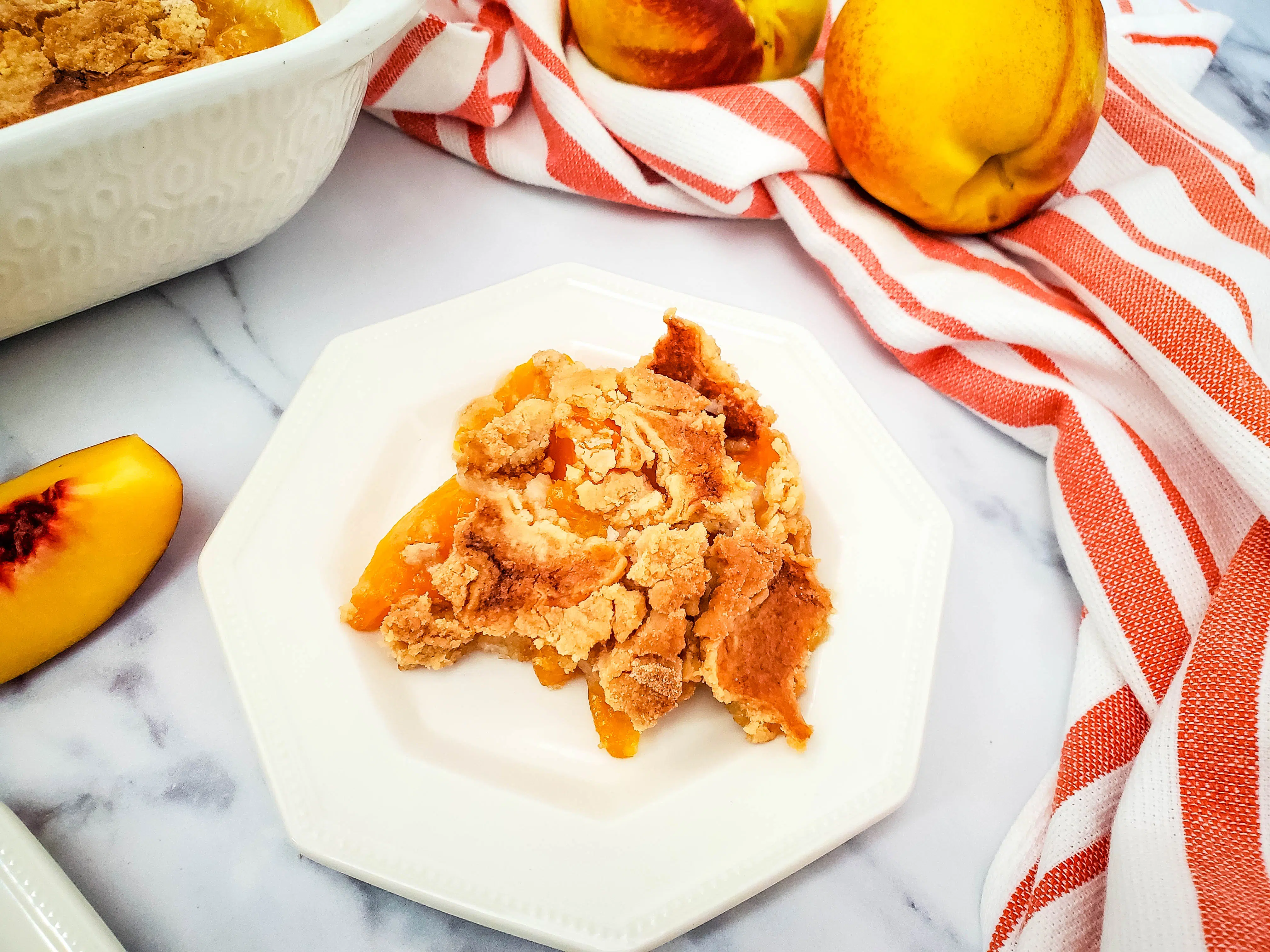 overhead view of peach dump cake on white plate
