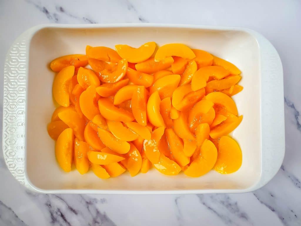 Easy Peach Dump Cake 3 peaches on a pan
