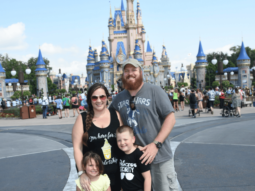 how much does it cost to go to disney world? family of four in front of Cinderella's Castle 