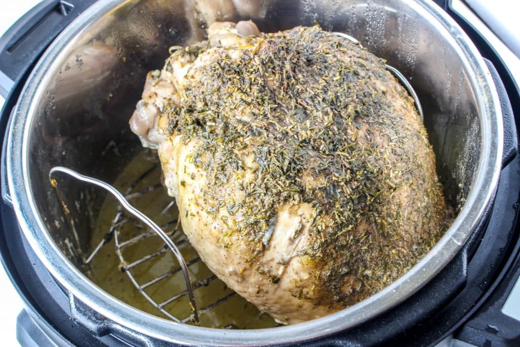 Quick Instant Pot Lemon and Herb Turkey Breast Recipe 15 what turkey breast with seasonings on top in instant pot with drippings below