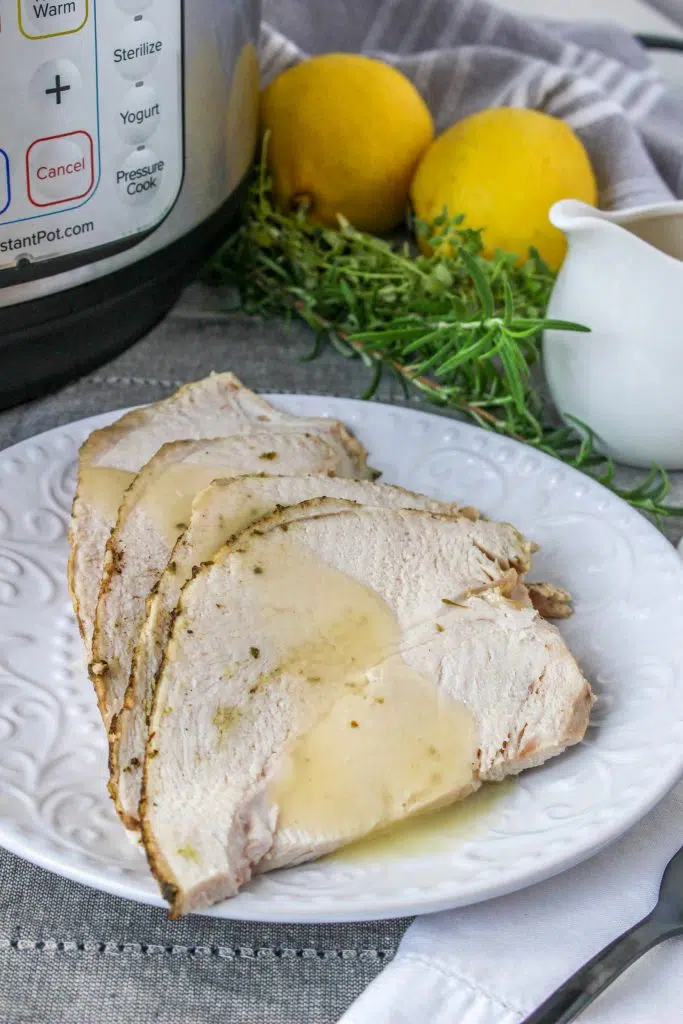 close up view of sliced instant pot turkey breast with gravy poured on top 