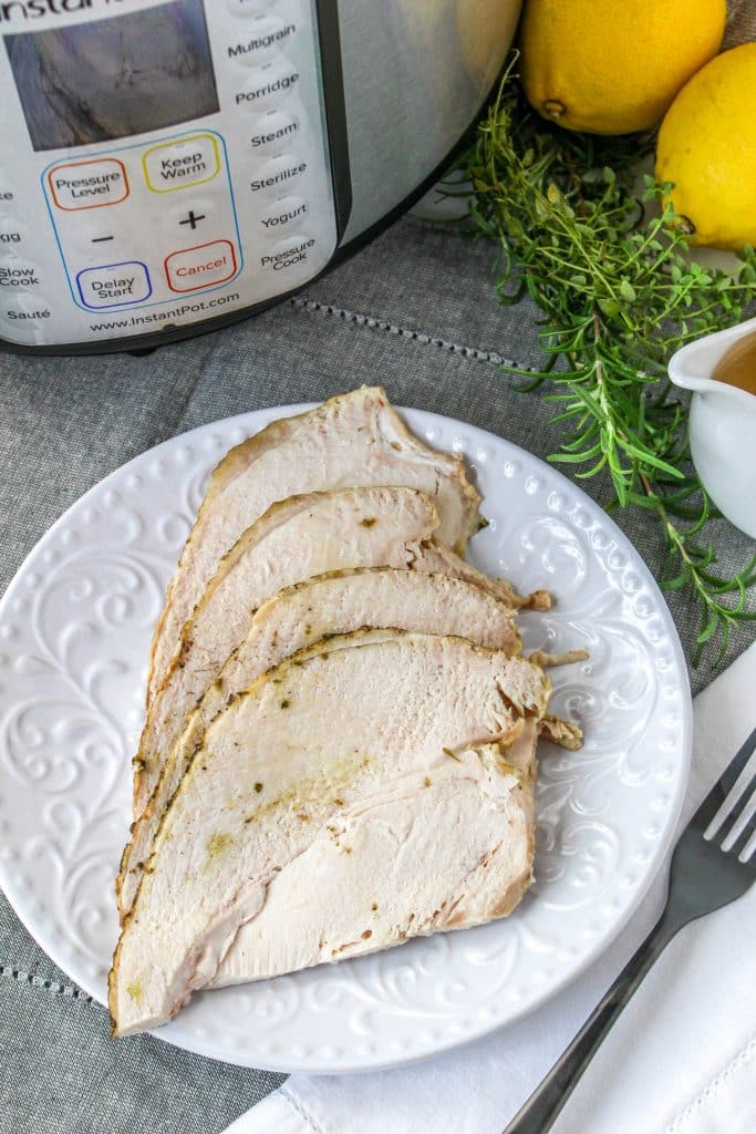 Quick Instant Pot Lemon and Herb Turkey Breast Recipe 7 overhead view of sliced lemon and herb sliced turkey breast on white plate