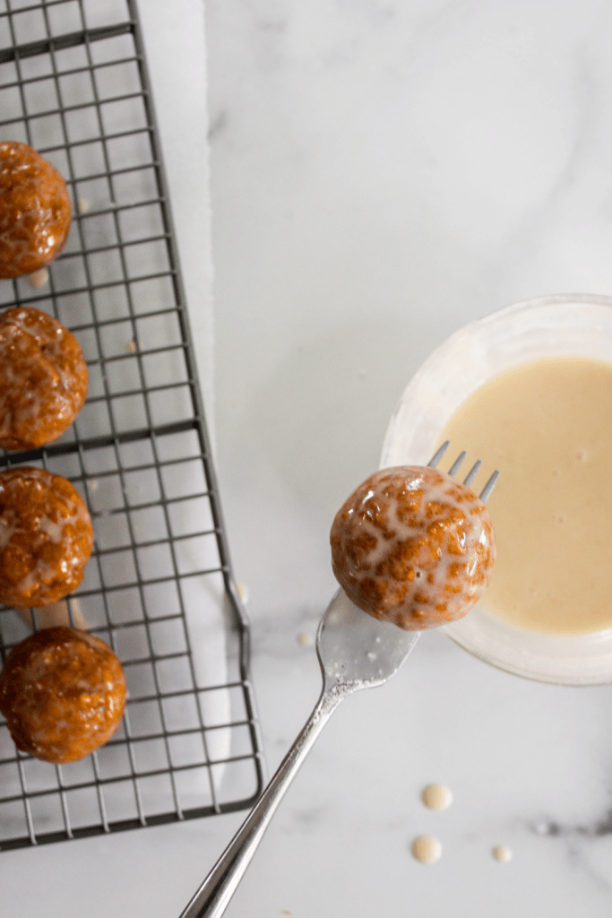 Glazed Pumpkin Donut Holes 13 pumpkin donuts dipping in glaze