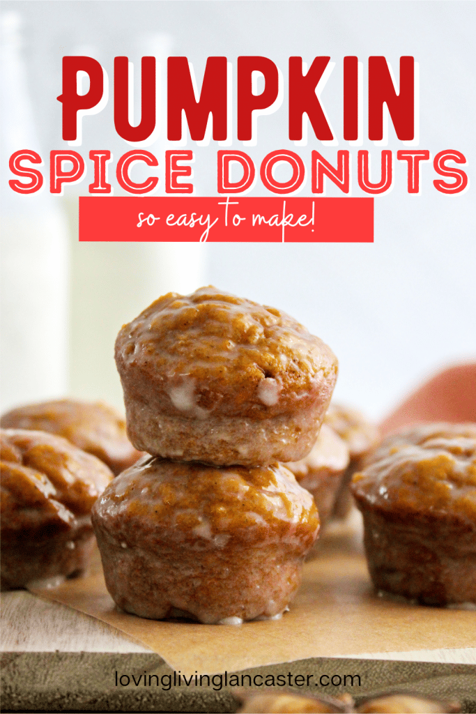 pumpkin donut holes with glaze stacked on wooden board.