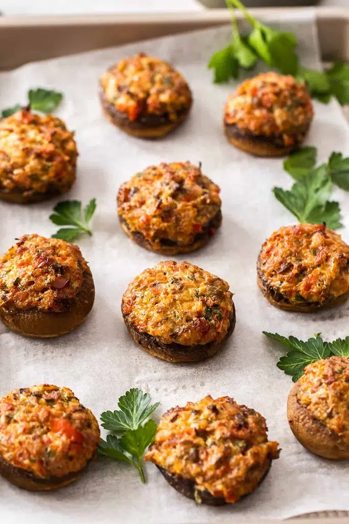 baked mushroom stuffed with cream cheese and bacon on parchment paper 