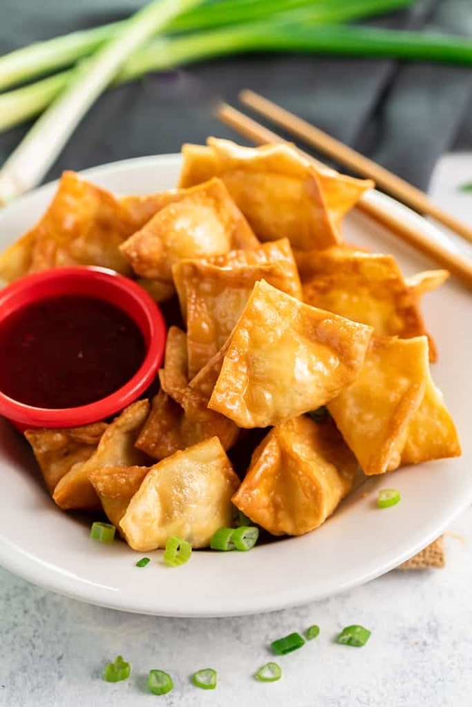 35 Party Appetizers For New Years Eve 19 crispy crab Rangoons with side of dip in red cup