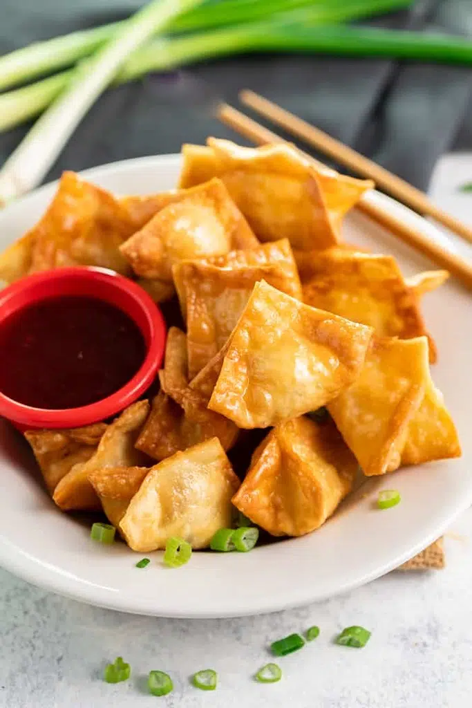 crispy crab Rangoons with side of dip in red cup 