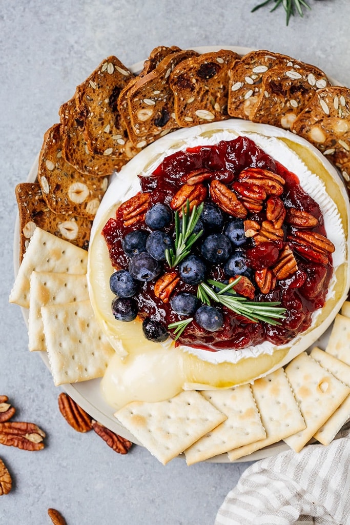 35 Party Appetizers For New Years Eve 20 baked Brie with cranberries, blueberries and nuts with crackers on the side