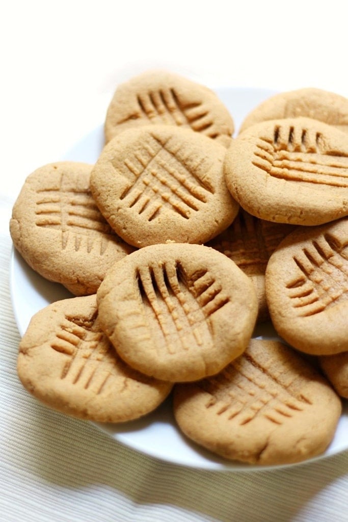 50 Easy Christmas Cookie Recipes with 7 Ingredients or Less 17 golden peanut butter cookies with fork cross imprint on top