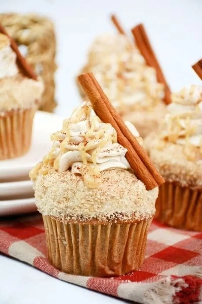 chai cupcakes with cinnamon stick on top of icing 