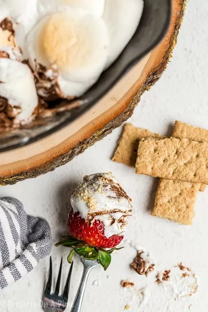 s'mores dip with strawberry and graham crackers on side 