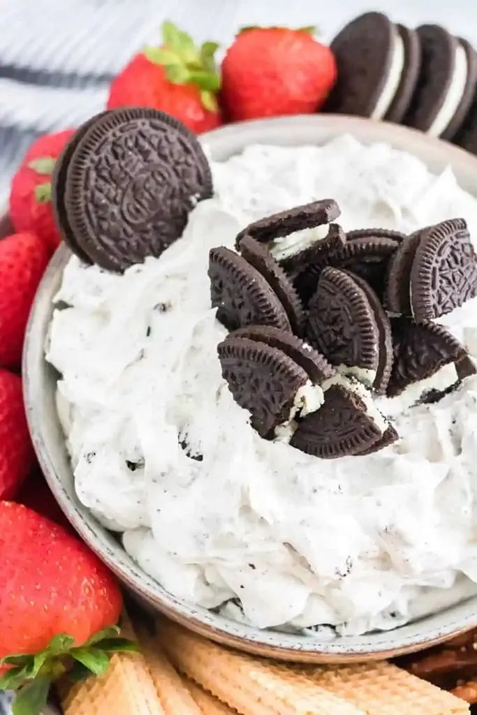 creamy white dip with crushed Oreos on top with strawberries on side 
