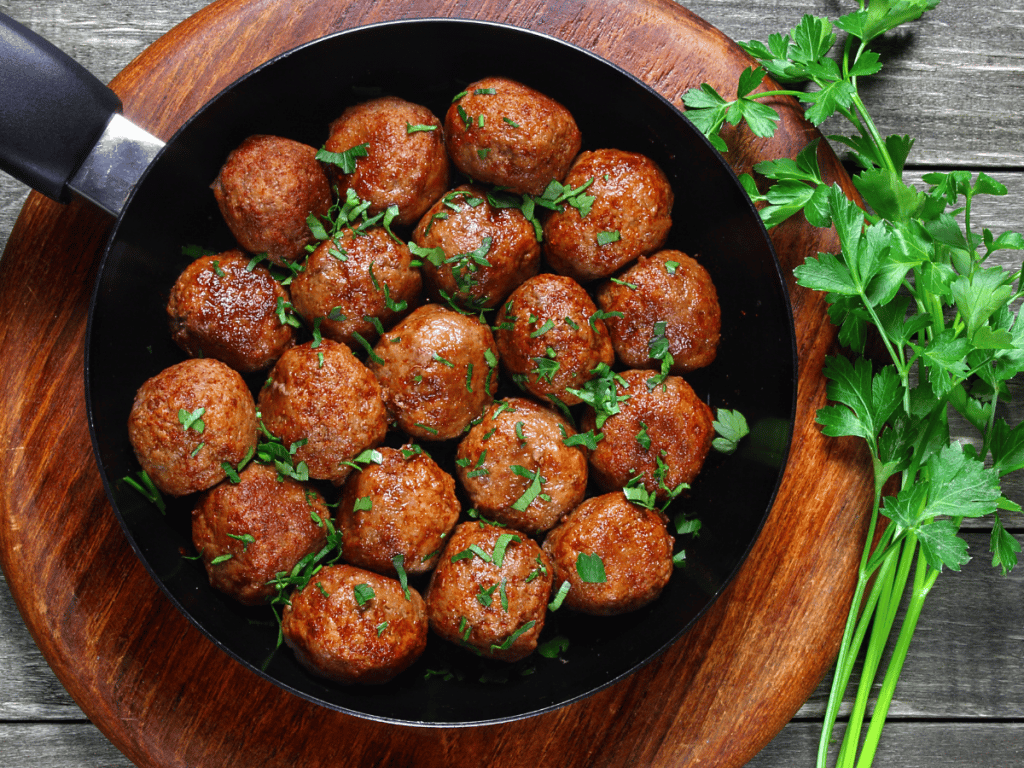 3 ingredient slow cooker meatballs in sauce pan on stove top 