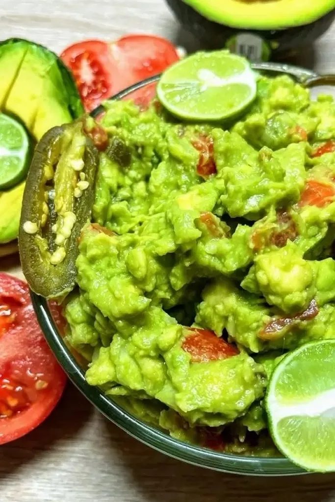 bowl of guacamole with jalapeño and lime 