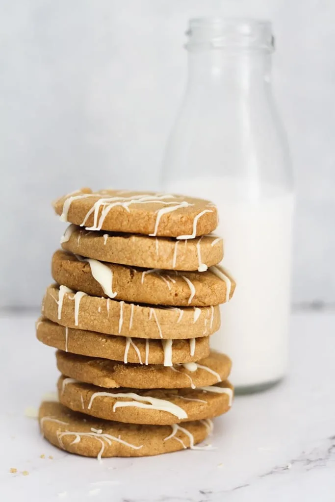 stack of biscoff shortbread cookies with glass of milk in background 