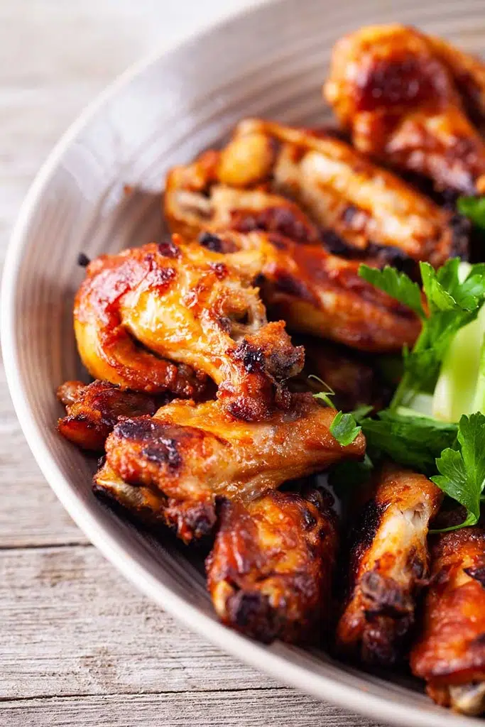 close up of chicken wings in white serving bowl 