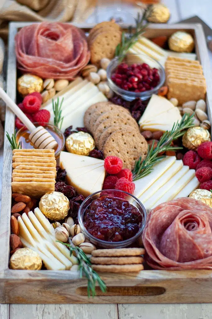 huge charcuterie board with crackers, jam, cheese and meat flowers 