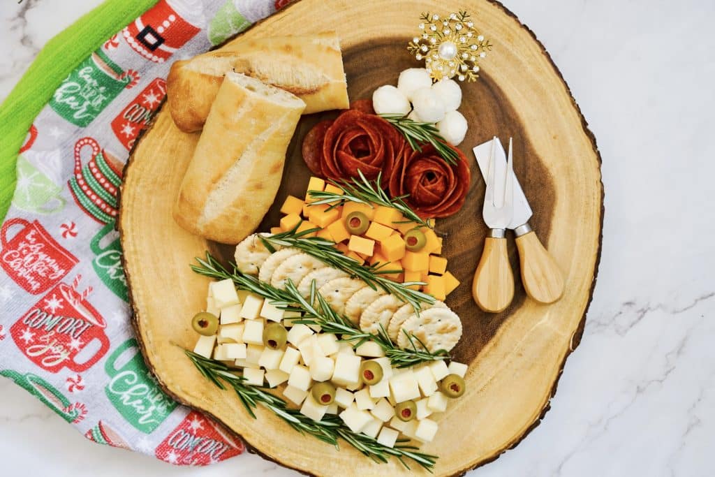 Easy Christmas Tree Charcuterie Board 13 cutting board with meat and cheese in the shape of Christmas tree on it with bread on side