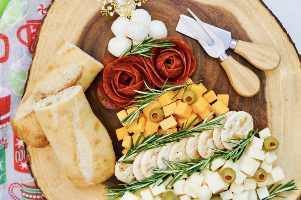 Easy Christmas Tree Charcuterie Board 11 cheese cubes, rosemary sprigs, bread and meat shaped as roses on circle platter