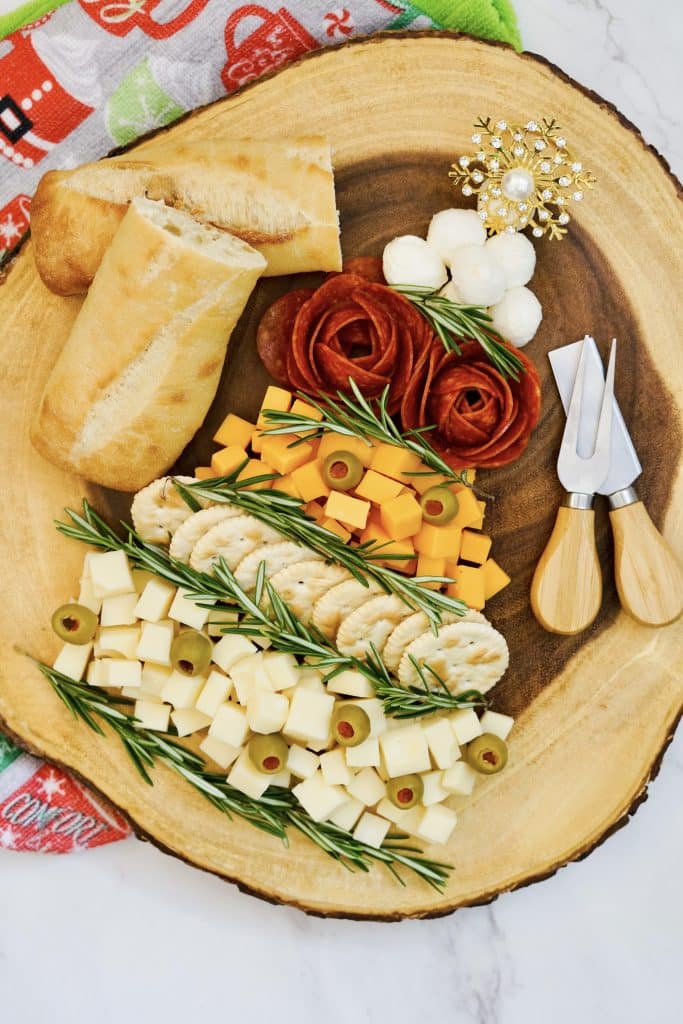 Easy Christmas Tree Charcuterie Board 10 meats and cheeses in Christmas tree form on circular wooden platter