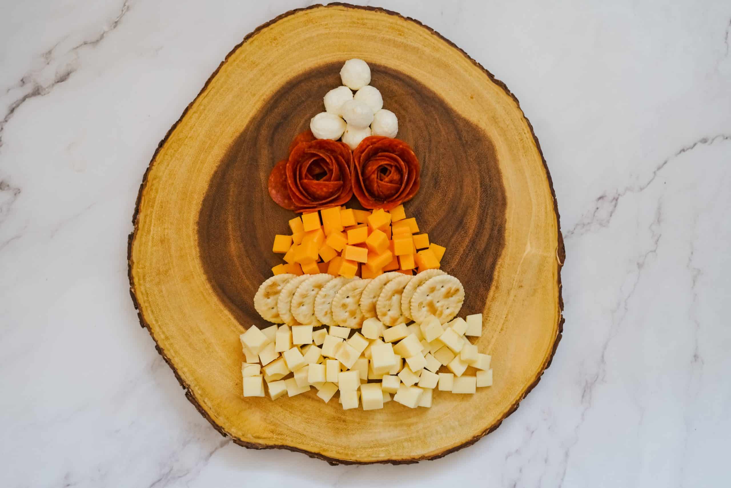 Easy Christmas Tree Charcuterie Board 5 meats and cheeses in tree shape on wooden cutting board