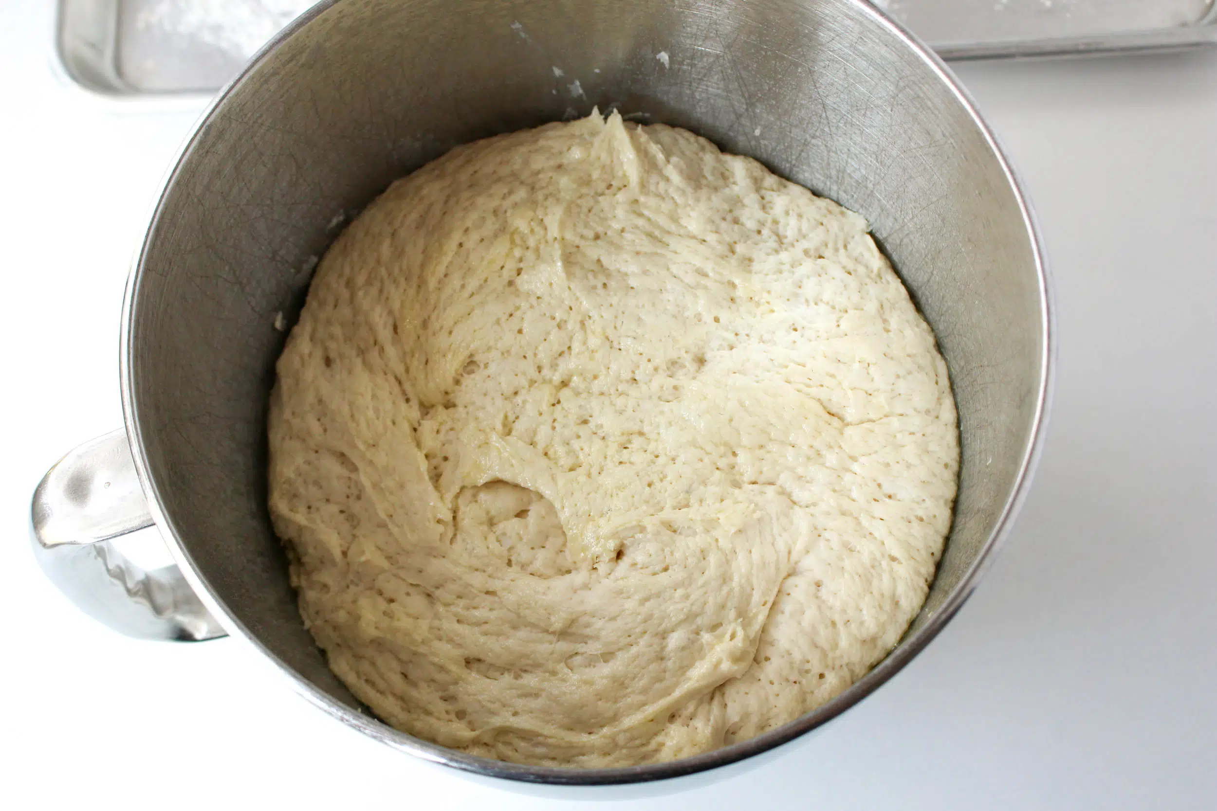 dough that has risen in stainless steel mixing bowl