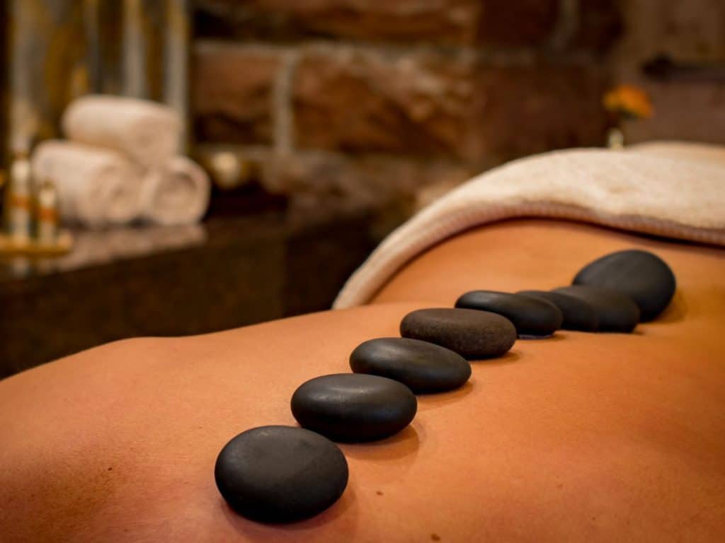The Best Spa in Gatlinburg, TN 5 Woman laying on a table with hot rocks on her back.