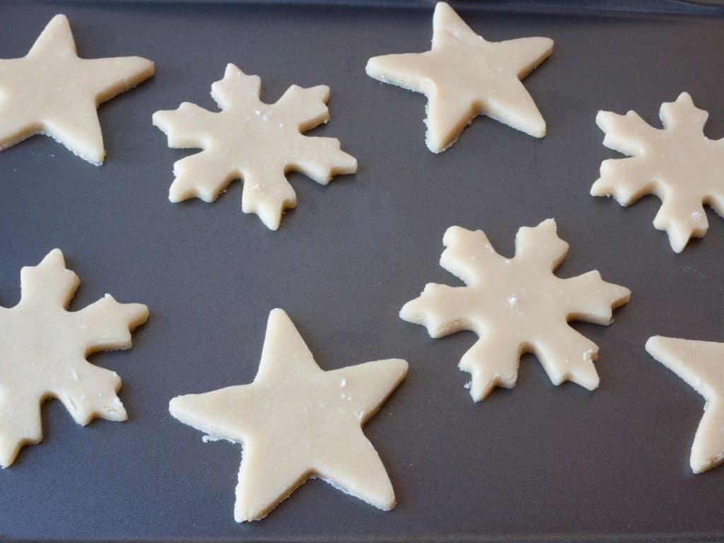 How to Fix Crumbly Sugar Cookie Dough 5 Star & snowflake sugar cookie dough on a cookie sheet.