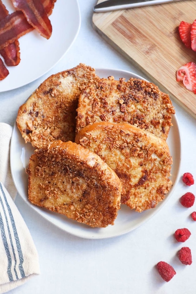 25 Valentine’s Day Breakfast Ideas For Kids 11 slices of cinnamon French toast on white plate with raspberries