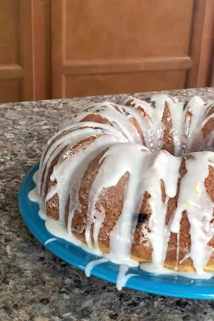 lemon blueberry bundt cake on clue plate with white icing